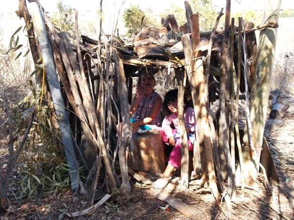 Kids outside secret fort made out of sticks